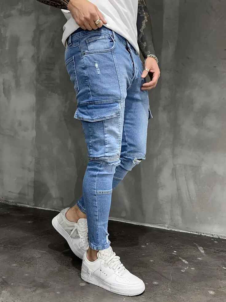 Trendy men's slim cargo jeans with side pockets and white sneakers.